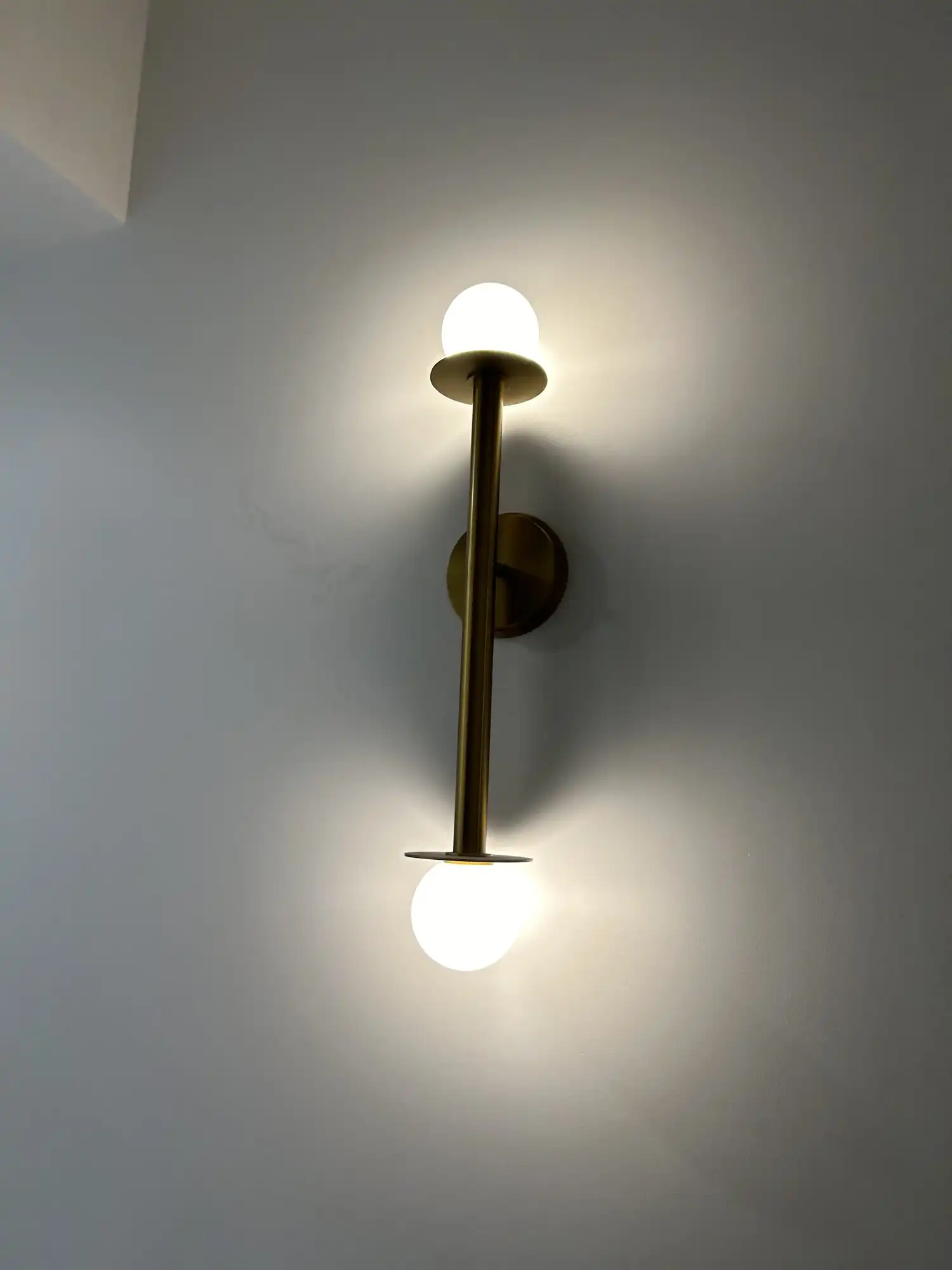 Brass double-globe wall sconce installed in a Bellevue high-rise condo by HB Power Electric