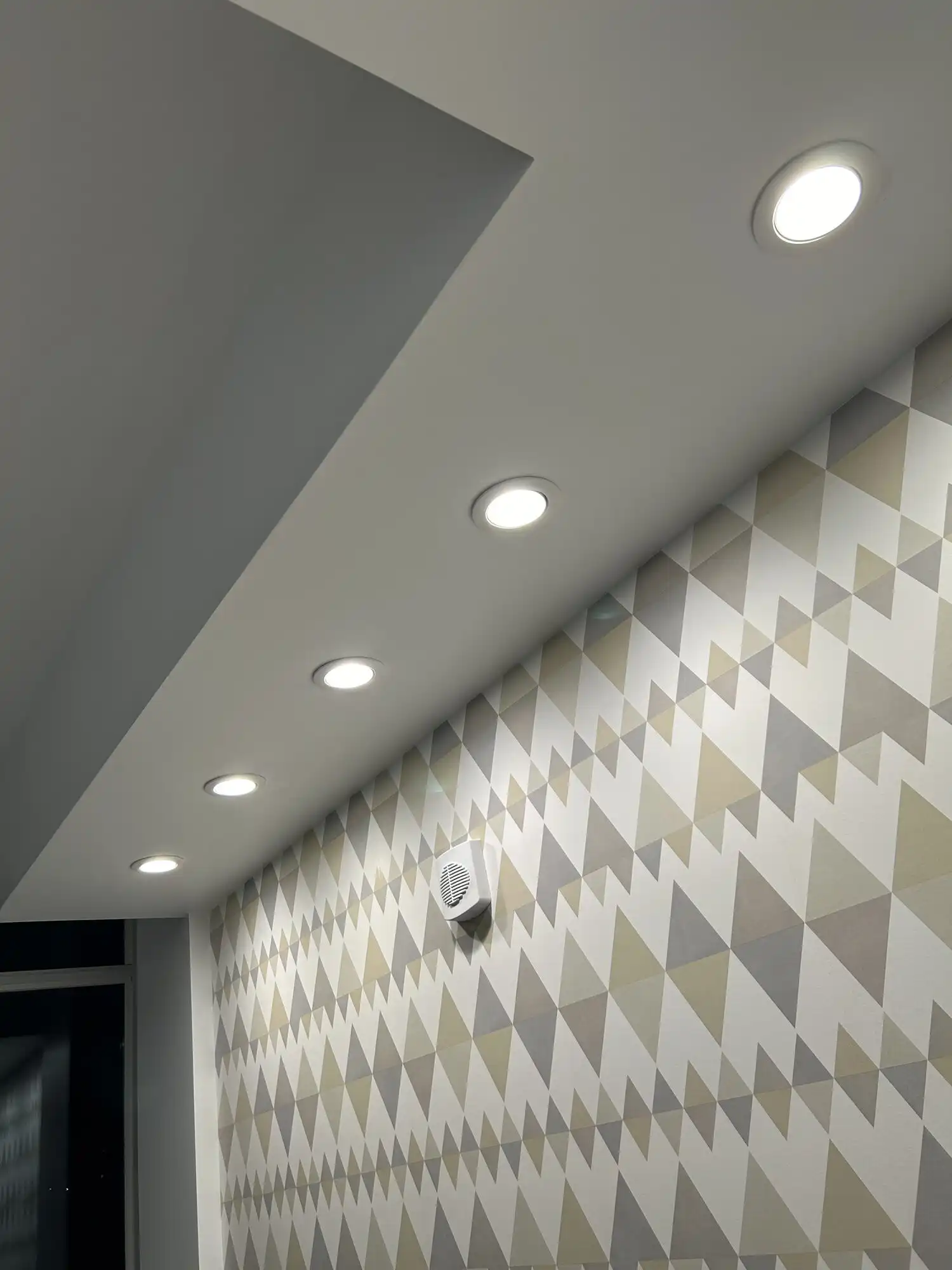 Recessed LED downlights in a soffit above a patterned accent wall in a Bellevue high-rise condo, Seattle-area electrician