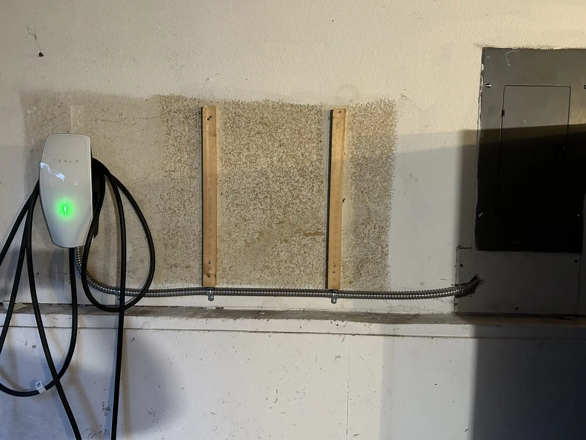 Tesla Wall Connector EV charger installed with metal conduit to garage panel in Federal Way WA