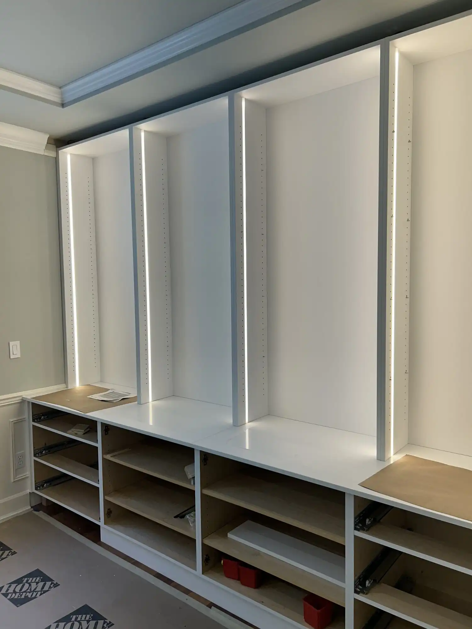 Vertical LED strip lights energized in custom built-in shelving, Sammamish WA millwork lighting install